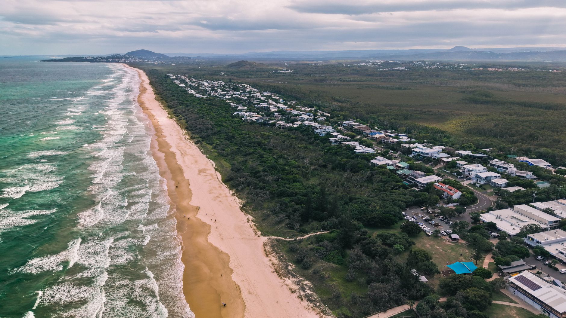 Stunning aerial view of the Sunshine Coast beach in Queensland, Australia, showcasing waves and coastal greenery.