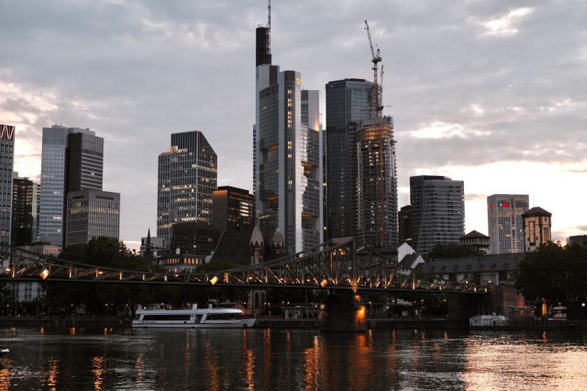 Frankfurt skyline featuring illuminated bridge and skyscrapers at dusk.
