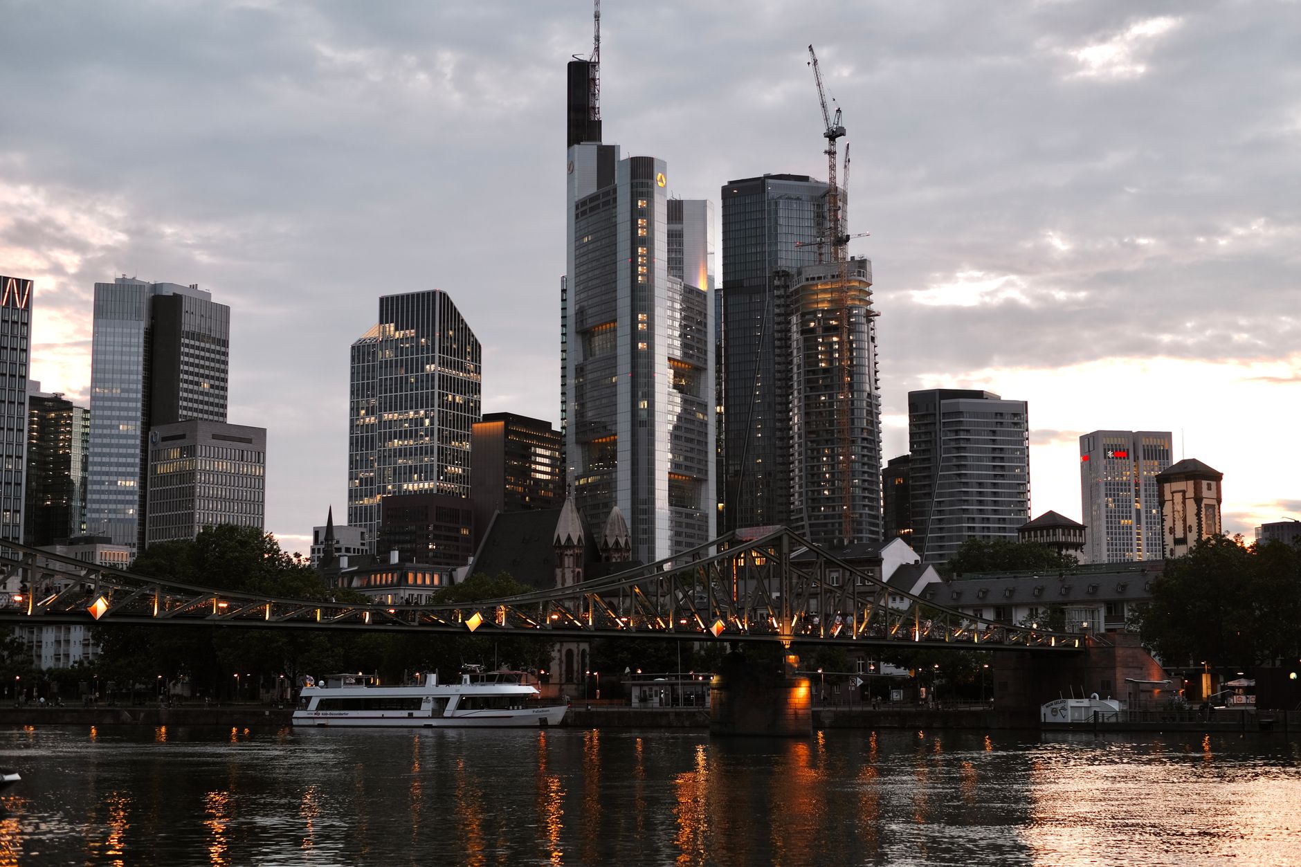 Frankfurt skyline featuring illuminated bridge and skyscrapers at dusk.