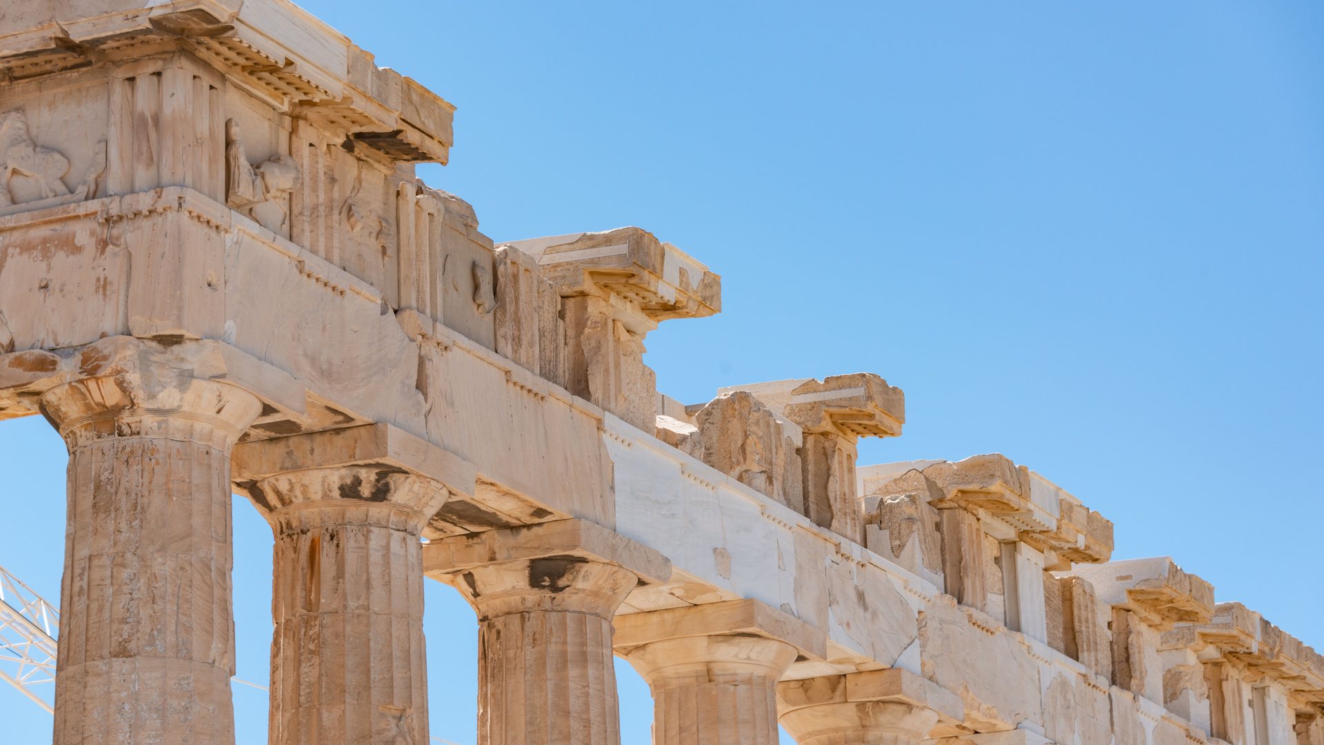 Greek island coastline and whitewashed architecture under a blue sky